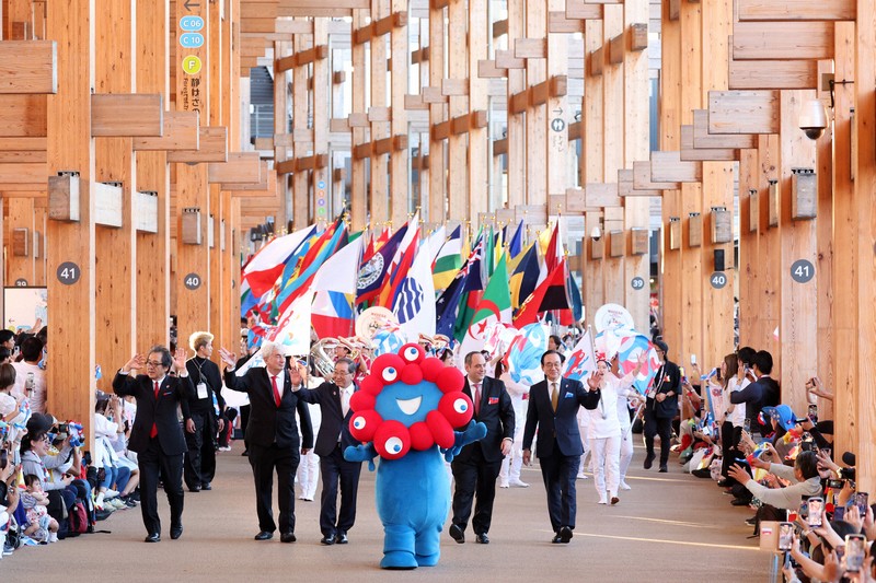 万博でフラッグパレード 参加国の国旗持ち350人が会場を行進 | 毎日新聞