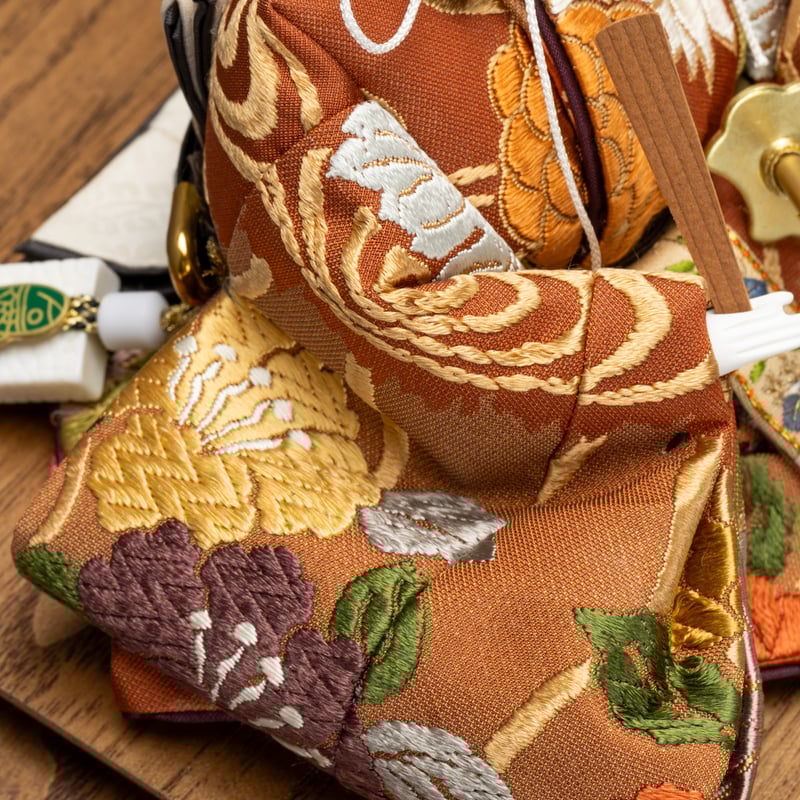 京十一番親王飾り「唐織袋帯：菊水に椿文錦」 | 桂雛／小佐畑人形店